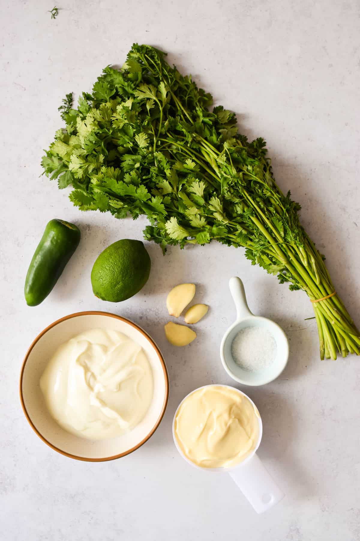 Ingredients needed to make this cilantro sauce on a kitchen counter .