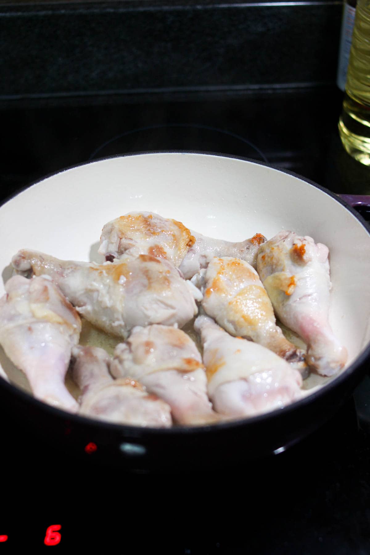 Chicken seared in a Dutch oven on the stove. 