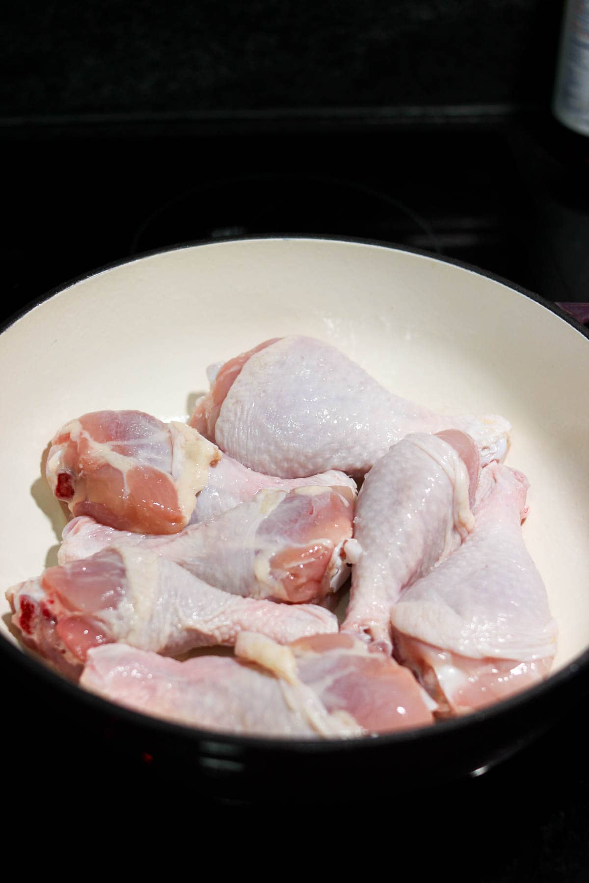 Raw chicken in a Dutch oven pot on the stove. 