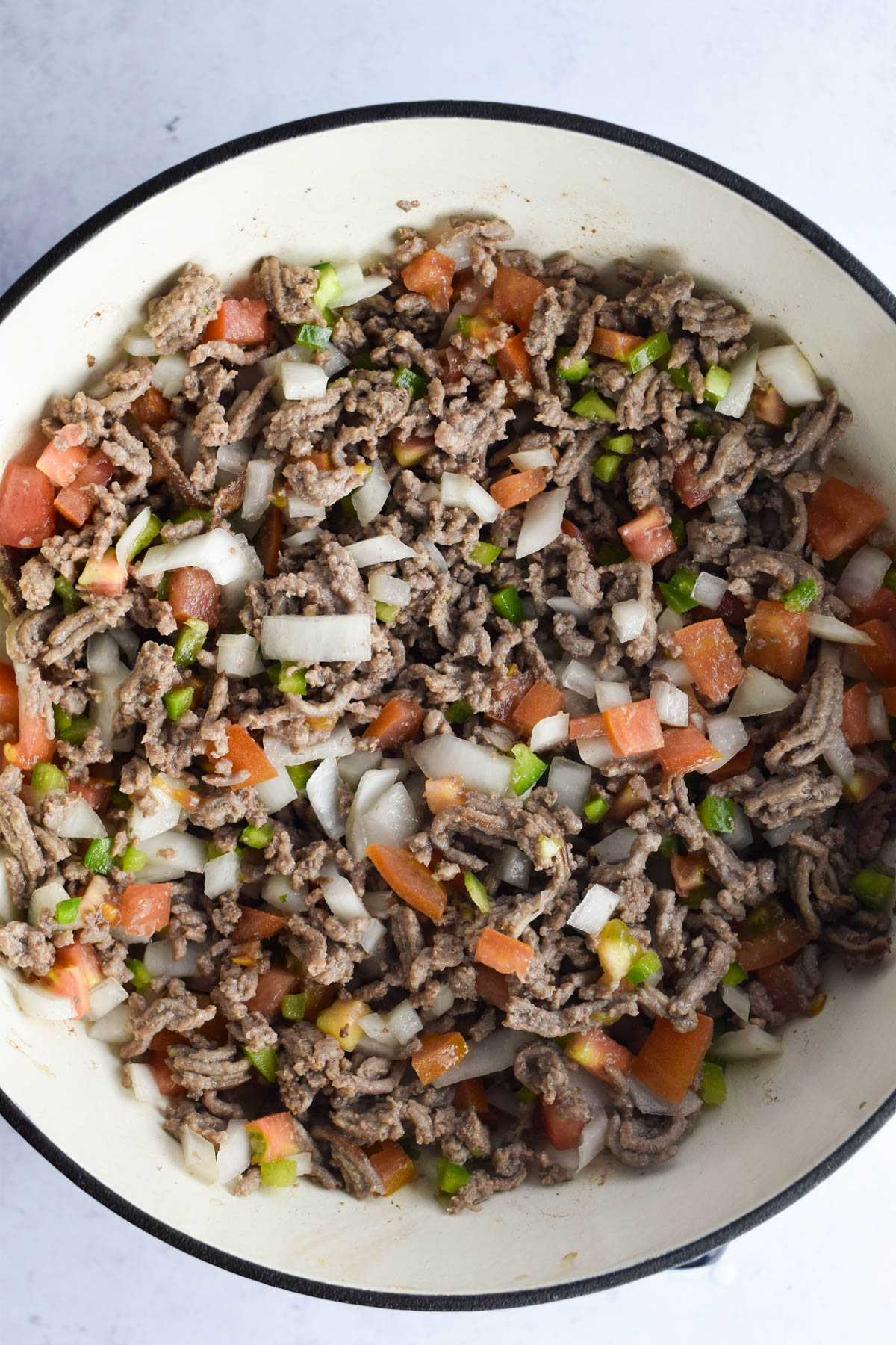 Vegetables and aromatics added to the browned beef. 