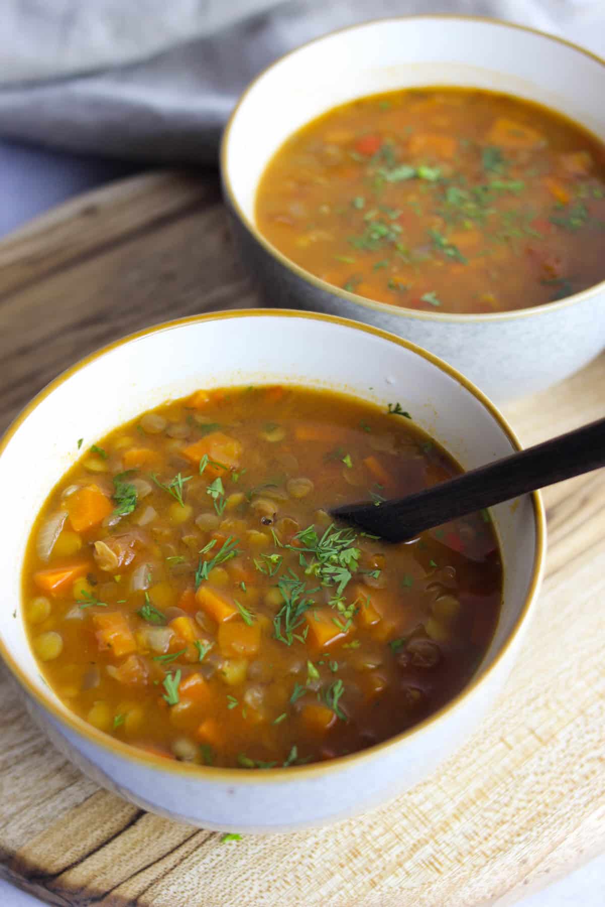 White bowls served with carrot and lentil soup.